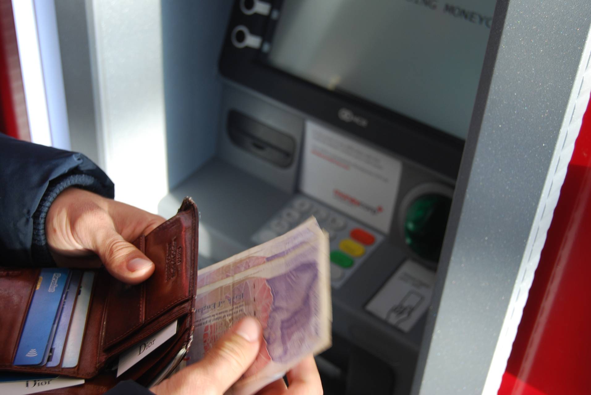 Photo of people drawing money from a ATM