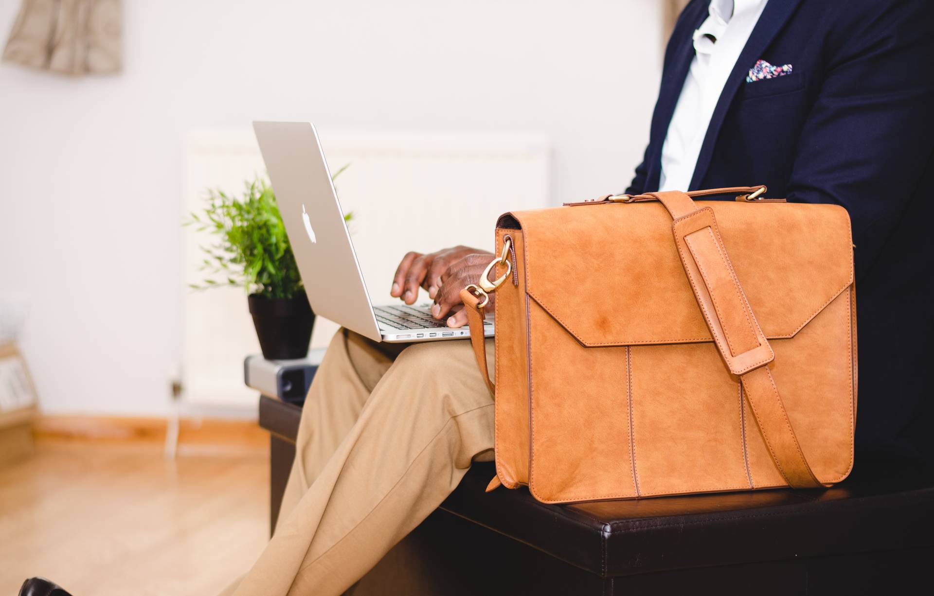 Man sits doing work while he prepares for his business trip